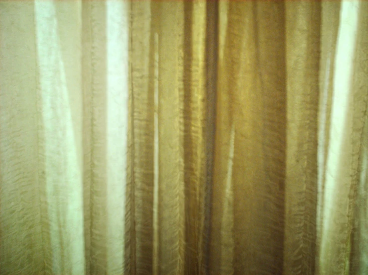 this is the side of a window covered with a sheer curtain