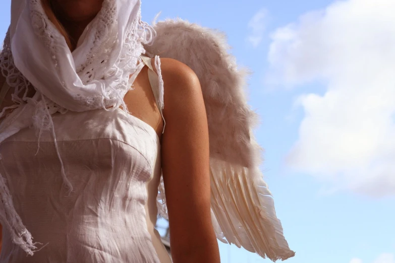 a woman wearing an angel costume holding a white umbrella