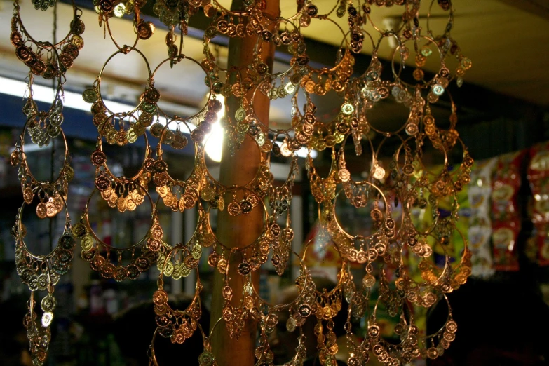 chandeliers in different colors are hanging on a pole