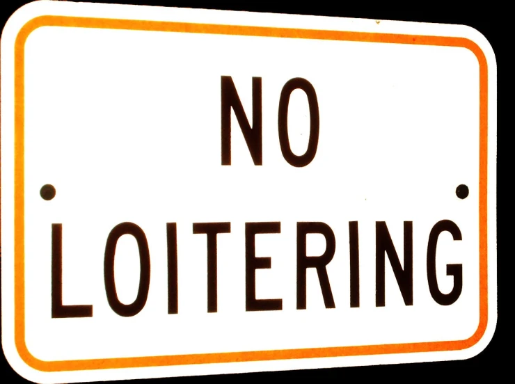 a large white sign that reads no loitering