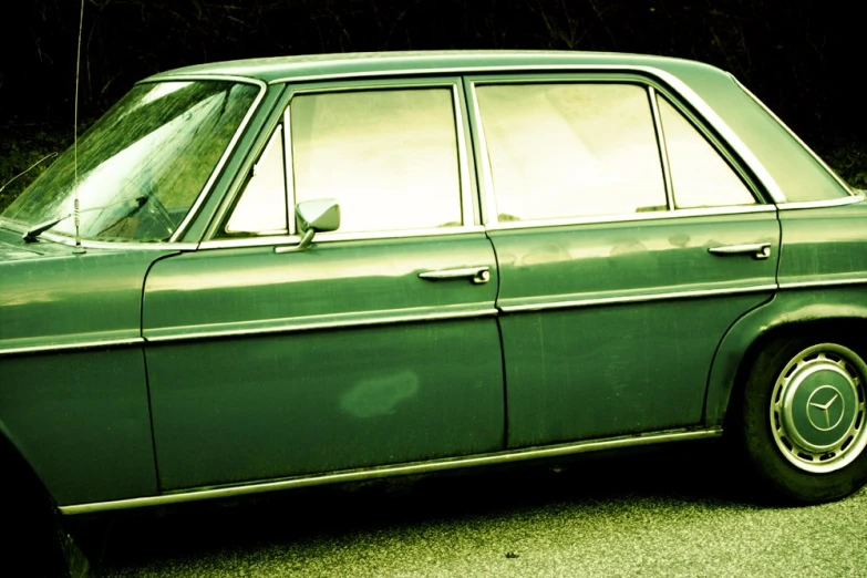 green car with wheels and rims parked on street