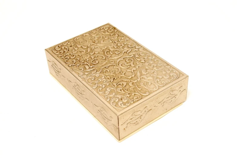 a large golden cigarette box sitting on top of a white table