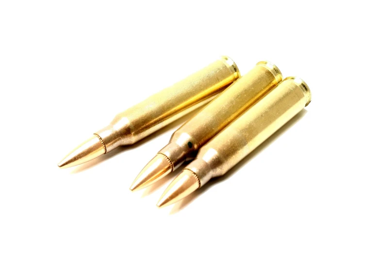 four bullet shells of one is on a white background