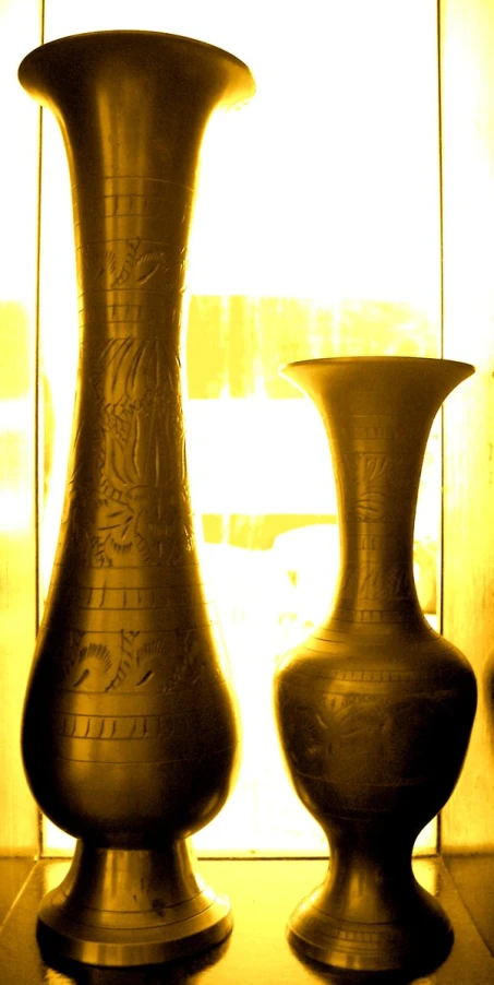 two large vases are in front of a window
