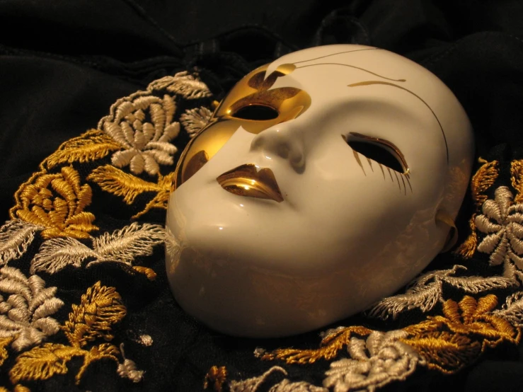 a white mask has golden jewels around it