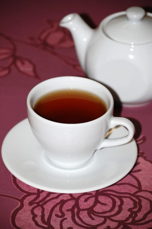 a white cup filled with black liquid sitting on top of a saucer