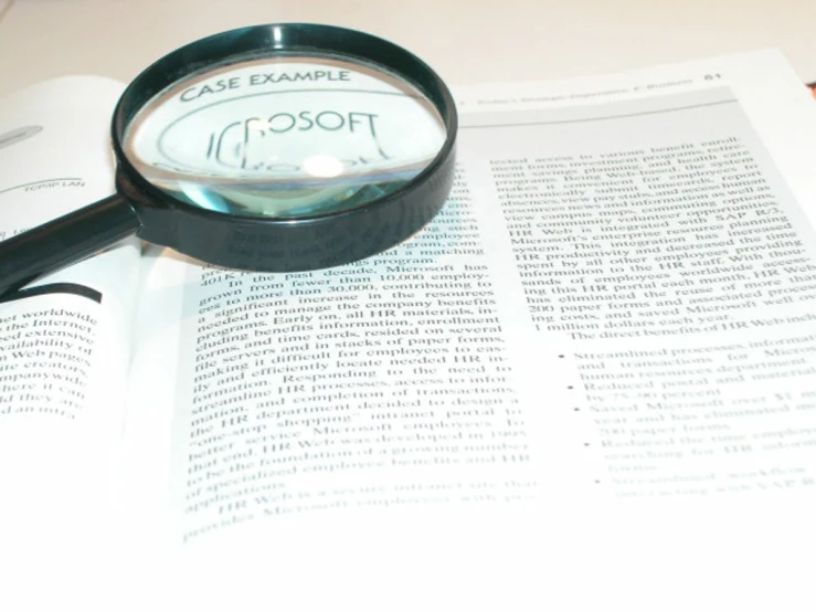 an opened book with an eye magnifier on it