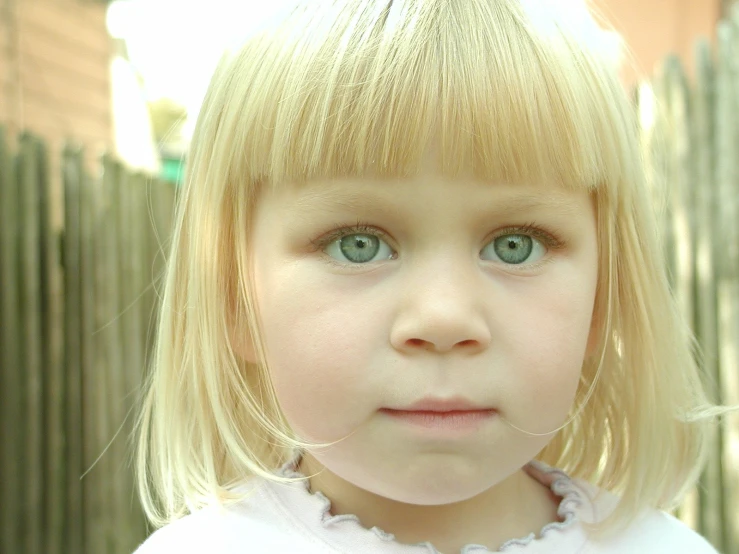 a young blonde girl with blue eyes and blonde hair