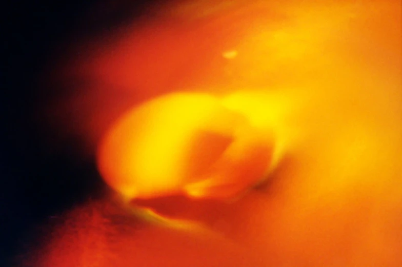 the back of an apple with a blurry image of an orange