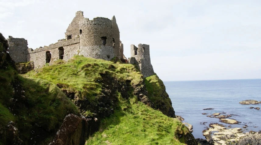 castle ruins overlooking the water and on top of a cliff