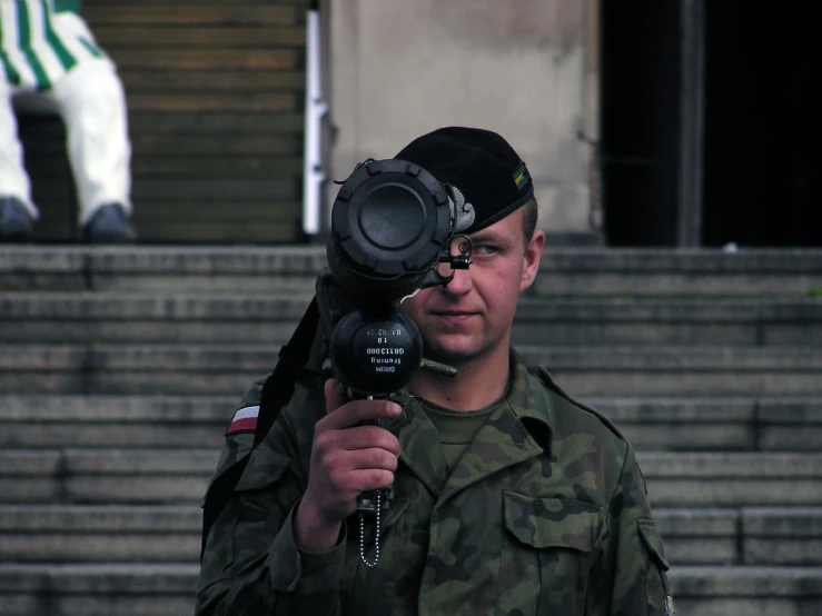 a man in a military uniform holding up a camera