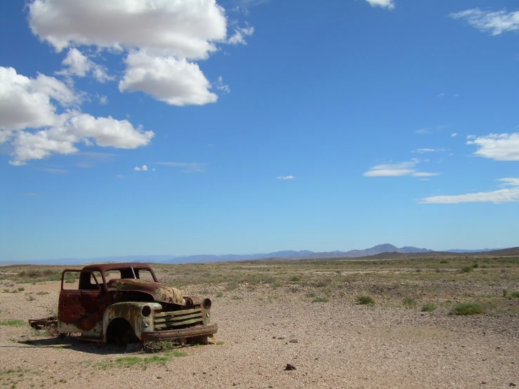 an old abandoned truck in a large field