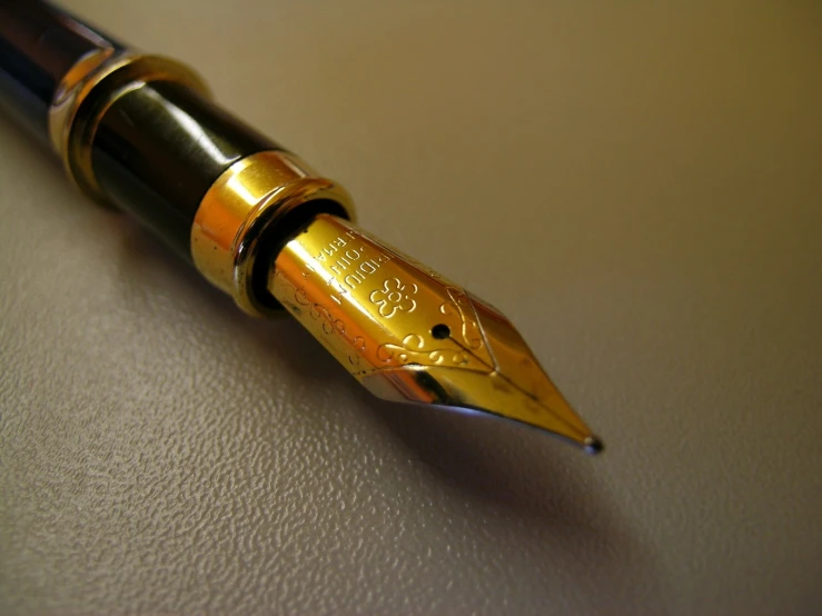 a golden fountain pen writing in its cap