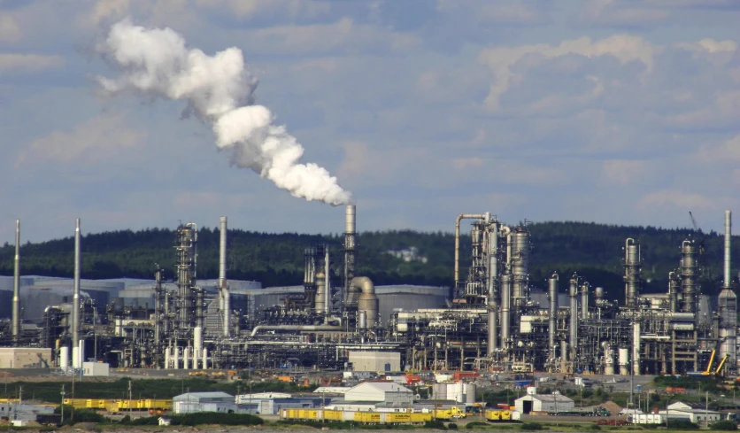 a large factory building with smoke coming from it's stacks