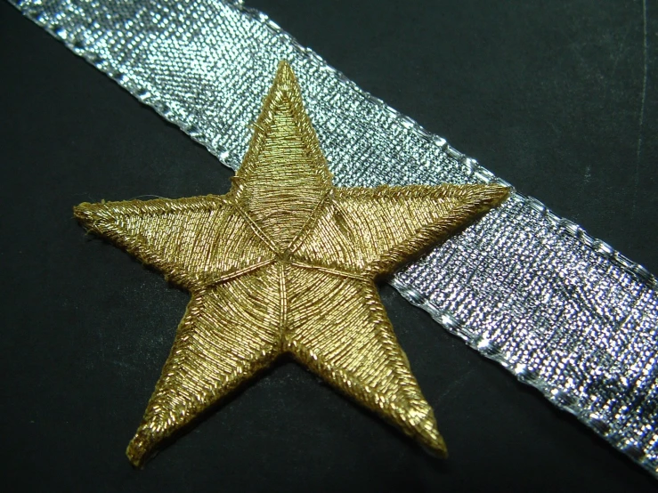 a star brooch sitting on top of blue and purple ribbons