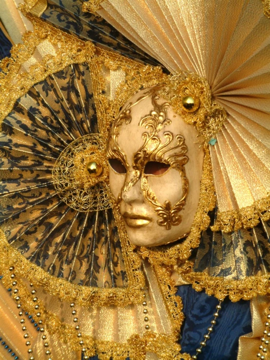 a masked in gold holding up his umbrella