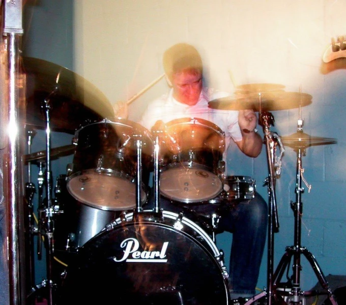 drummer playing drums while sitting down in his room