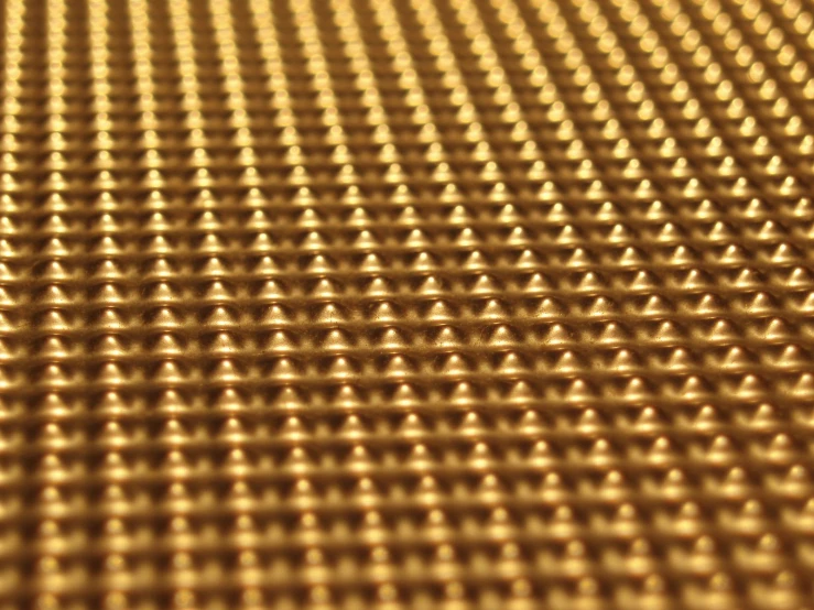 a metallic surface with lots of brown dots