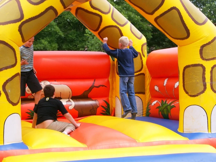 children and adults are in an inflatable structure with a giraffe theme