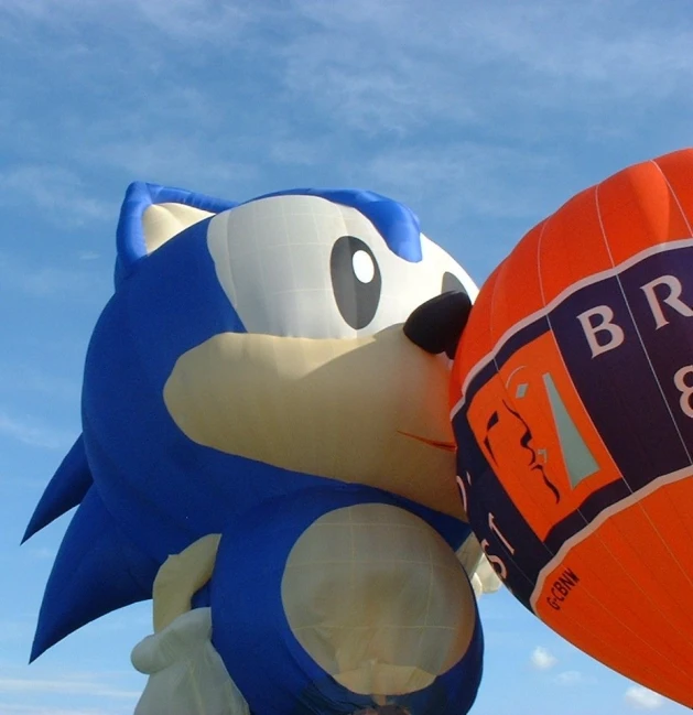 an orange and blue balloon in the shape of a sonic the hedgehog holding onto another balloon