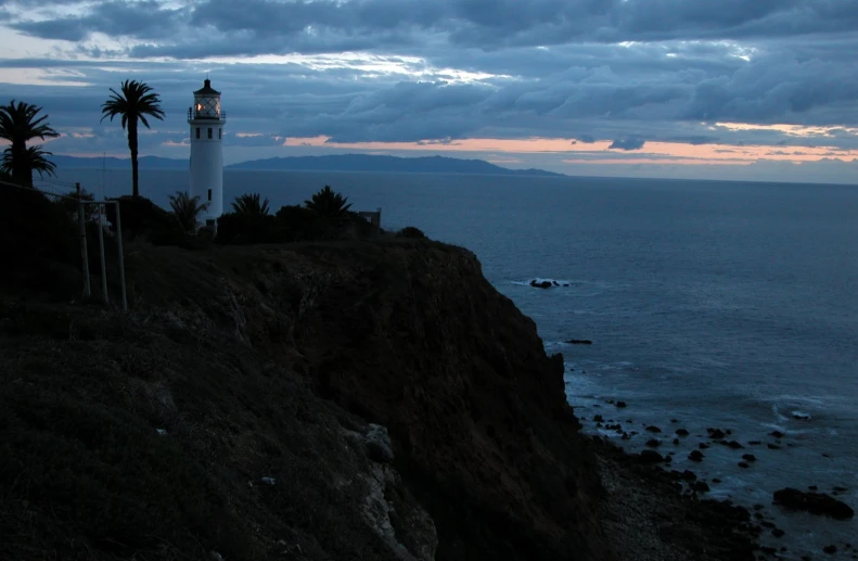 a lighthouse perched on the edge of a cliff