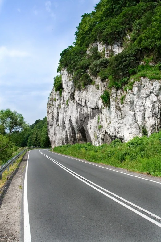 a empty road passes between several cliffs