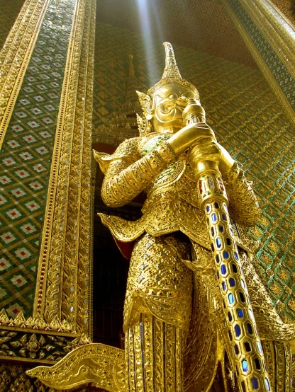 an ornate statue in the shape of a gold frog in front of a mirror ceiling