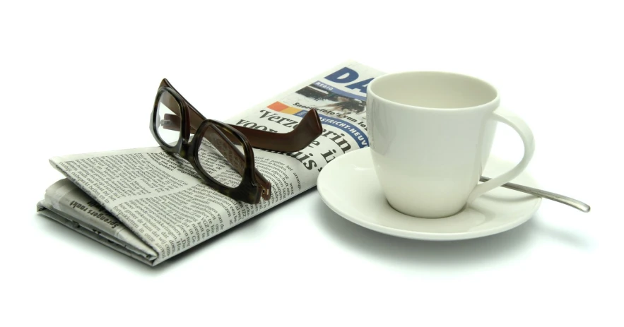 glasses, newspaper and eyeglasses are sitting on top of the table