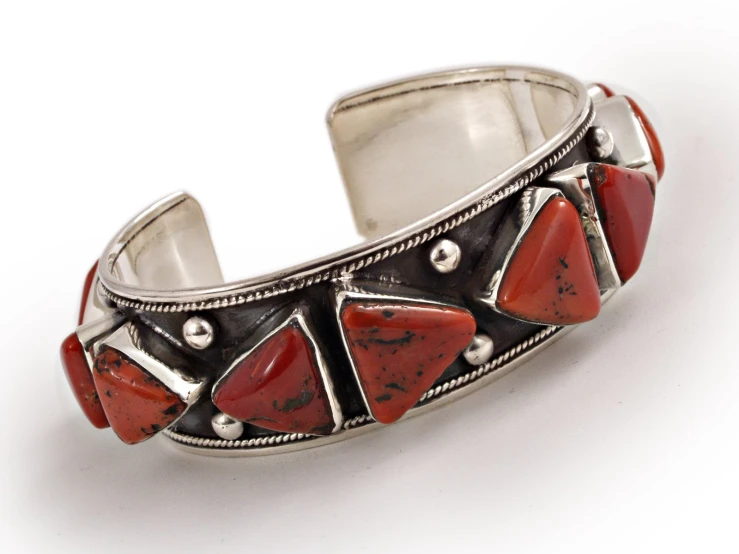 a silver celet with coral beads and two small squares