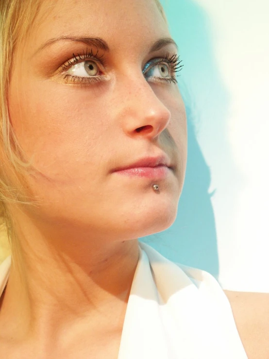 a woman with blue eyes looking over her shoulder