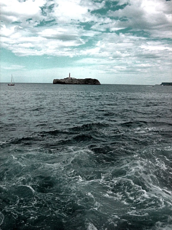 an image of a boat sailing near a small island