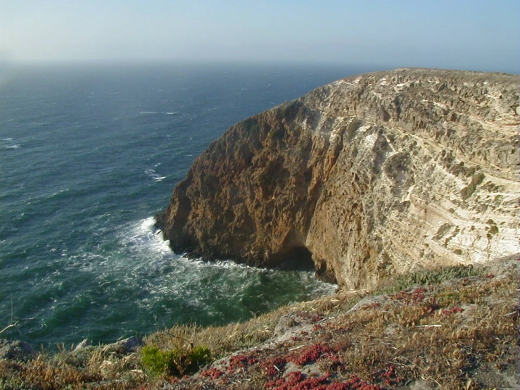 an overcast sky and the ocean near the cliff