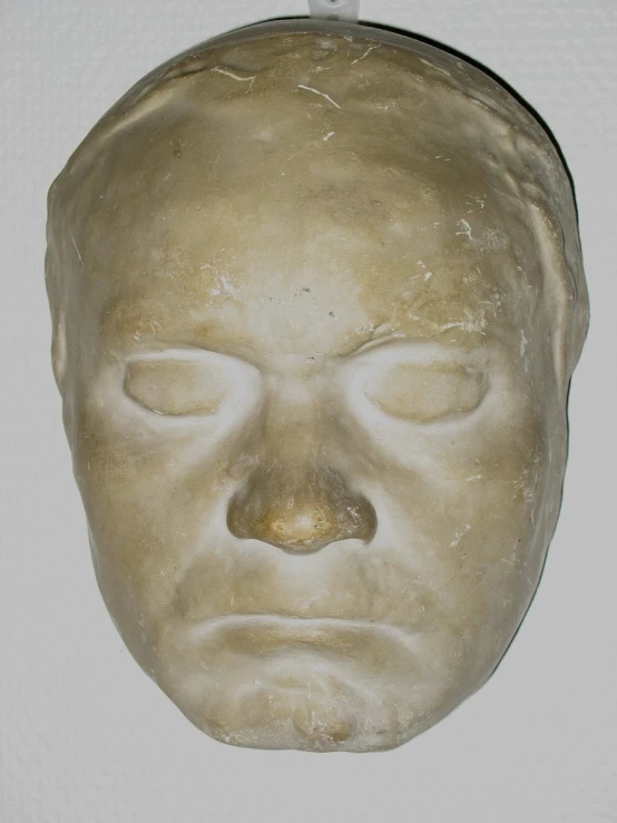 a clay head with closed eyes in the shape of a face