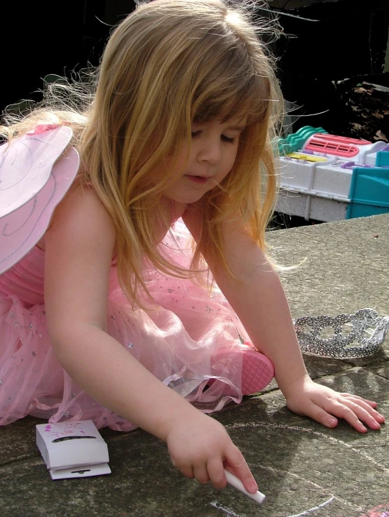 a little girl in a dress lays down with a box on her lap