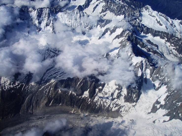 the view from an airplane looking over a snowy mountain