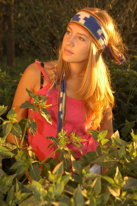 a woman is wearing a bright dress in some leaves