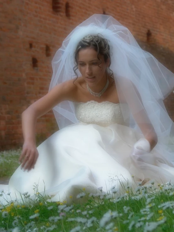 a woman in a white dress is wearing a veil and gloves