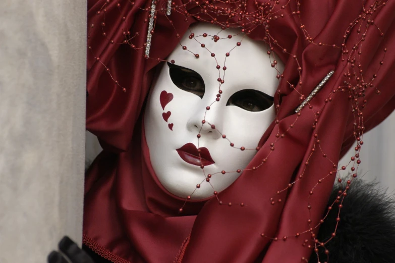 the mask is covered by beads and red cloths