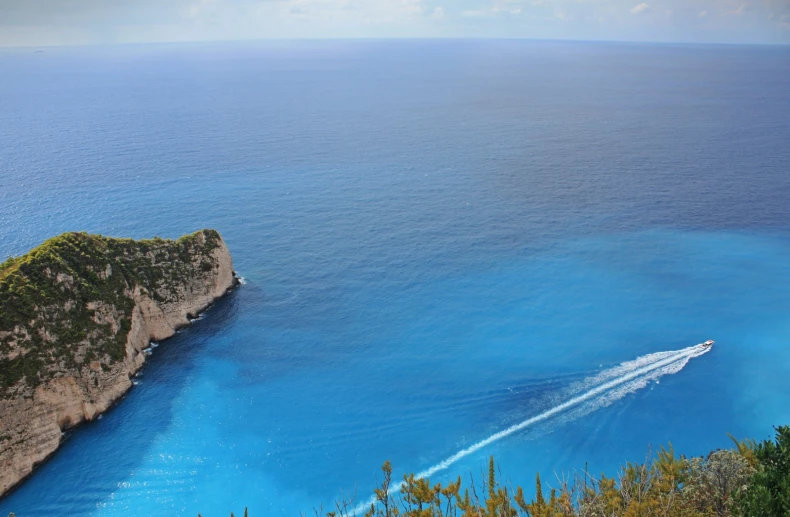 boat leaving a wake across the crystal blue water