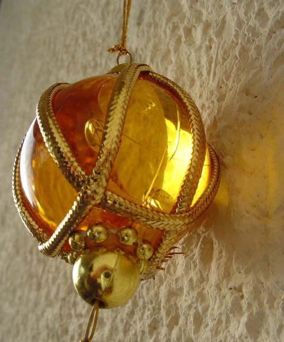 an ornate golden item hangs from a cord