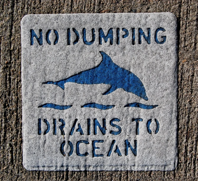 there is a sign that says no dumping drains to ocean