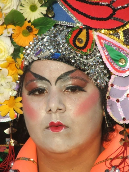 an oriental woman with a flowered headdress poses for a picture