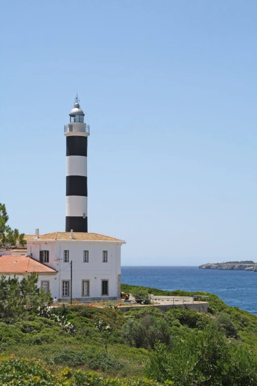 an image of the lighthouse on a hill by the ocean