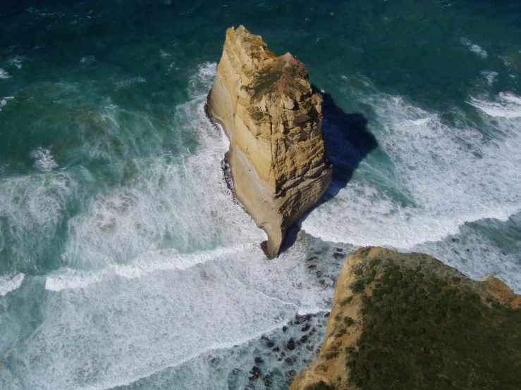 a rocky coast next to the ocean with rough waves