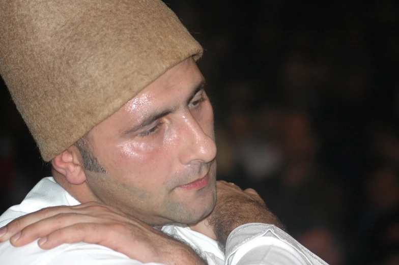 a close up image of a man wearing a hat