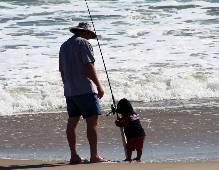 a man and a young child fishing in the ocean