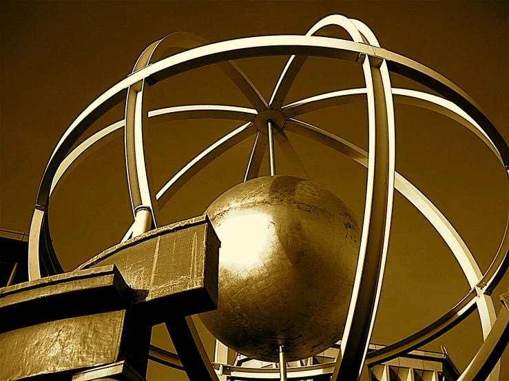 a golden ball is hanging from an iron structure