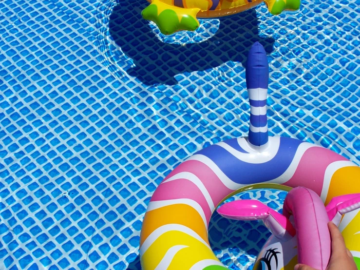 person standing next to float ring in pool