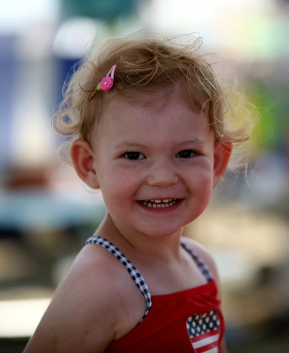 a child with hair up and a bow around its head