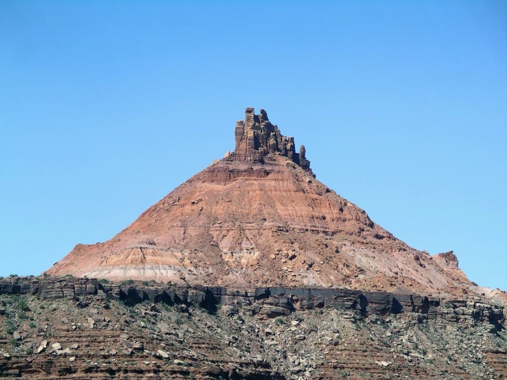 the mountain is high above the water near the boat